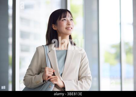 Japanische Geschäftsfrau geht aus dem Büro Stockfoto
