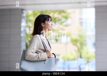 Japanische Geschäftsfrau geht aus dem Büro Stockfoto