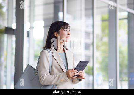 Japanische Geschäftsfrau geht aus dem Büro Stockfoto