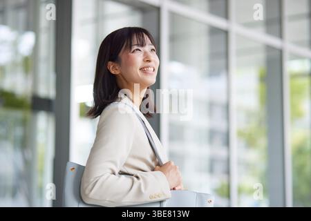 Japanische Geschäftsfrau geht aus dem Büro Stockfoto