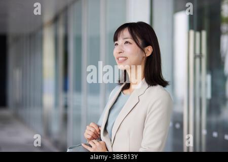 Japanische Geschäftsfrau geht aus dem Büro Stockfoto