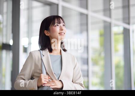 Japanische Geschäftsfrau geht aus dem Büro Stockfoto