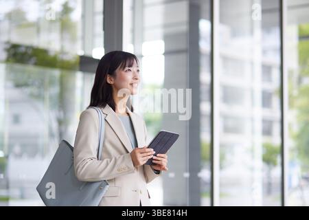 Japanische Geschäftsfrau geht aus dem Büro Stockfoto