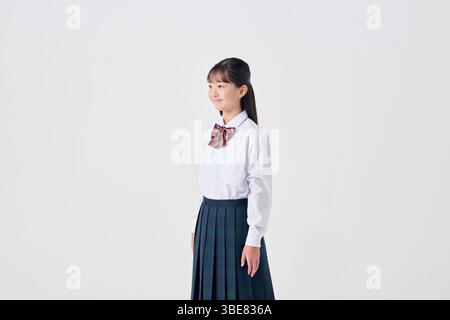 Weißer Hintergrund, japanisches Mädchen der Junior High School, lächelnd Stockfoto
