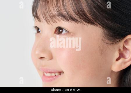 Weißer Hintergrund, japanisches Mädchen der Junior High School, lächelnd Stockfoto