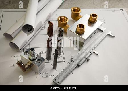 Metallbearbeitungswerkzeuge und Teile auf einer technischen Zeichnung, die Fertigungs- und Konstruktionskonzepte darstellen. Stockfoto