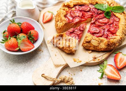 Frisch gebackene Erdbeergalette, dekoriert mit Mandelflocken und Minzblättern, mit einem Ausschnitt Stockfoto