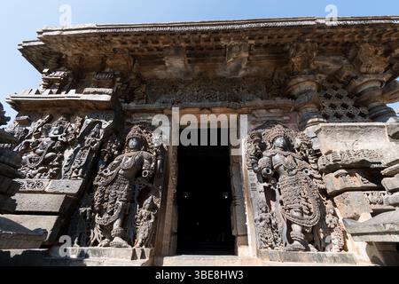 Reich verzierte Skulpturen von Dwarapalas (Torwächter) am Eingang zum antiken Hoysaleshwara Tempelkomplex in Halebidu in Karnataka. Stockfoto