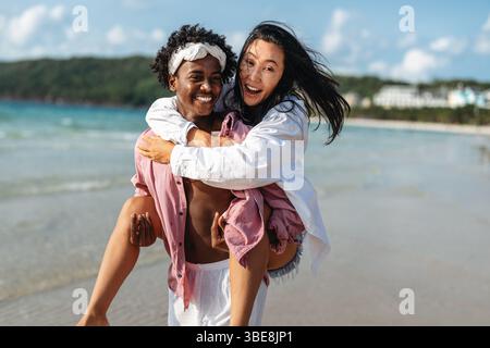 Reines Glück. Ein junges, vielseitiges, multiethnisches Paar genießt jeden Moment ihres tropischen Urlaubs Stockfoto