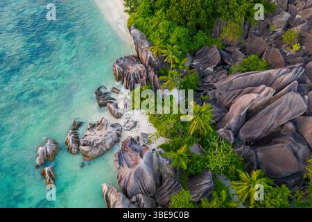 Blick von der Drohne auf den einzigartigen berühmten tropischen Strand Anse Source D'Argent Granitfelsen blaues Meer und Palmen auf La Digue Insel Seychellen Stockfoto
