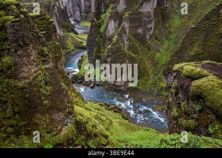 Blick auf den Fluss, der durch das Kanu Fjadrargljufur fließt, bedeckt mit grünem Gras und Moos auf Island dramatische Landschaft Stockfoto