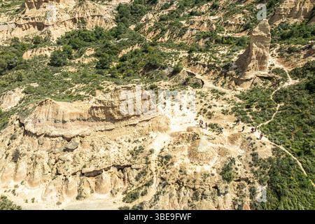 Gruppe von Wanderern an bunten Sandsteinformationen, Wüste, entlang der Schotterstraße Ruta Jubierre, aus der Vogelperspektive, Desierto de los Monegros, Spanien Stockfoto