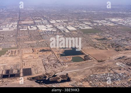Aus der Vogelperspektive auf Kiesgruben, Wohngebiete und ein großes Industriegebiet im Südwesten von Phoenix, Arizona. Stockfoto