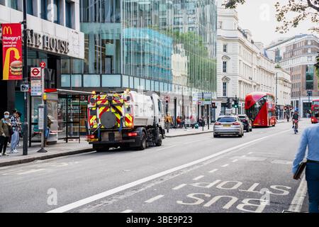London, England, 12. Juli 2023, Street Sweeper Reinigung der Straßen in der belebten London Street und Fußgänger im Hintergrund, die Urban Cleanlines hervorheben Stockfoto