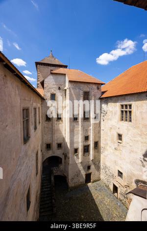 Mittelalterlicher Innenhof der Wasserburg Svihov mit Turm und orangefarbenem Dach an sonnigen Sommertagen in Tschechien Stockfoto
