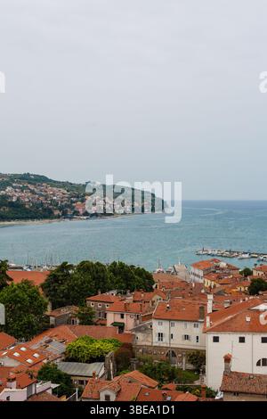 Koper, Slowenien. Ein Blick aus der Vogelperspektive auf die Küstenstadt mit ihren roten Dächern, die sich bis zur Adria erstrecken. Der Kontext ist eine mediterrane Stadtlandschaft Stockfoto