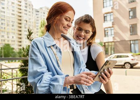 Zwei junge Frauen unterhalten sich und lachen, während sie ihre Zeit im Freien genießen. Stockfoto