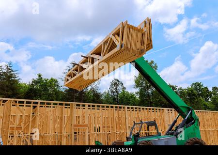 Telehandler manövriert Holz auf Baustellen, die von Bäumen umgeben sind Stockfoto