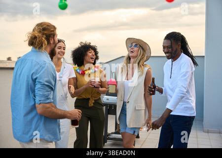Freunde genießen Drinks und lachen auf einer Dachparty Stockfoto