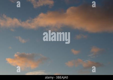 Captura un instante de serena belleza donde el cielo se convierte en un lienzo Vibrante al atardecer. Las nubes, teñidas con suaves matices de durazno Stockfoto
