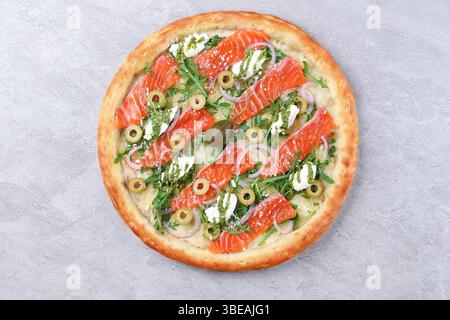 Handgemachte geräucherte Lachs-Pizza mit Arugula-Ziegenkäse und Pesto-Drizzle Stockfoto
