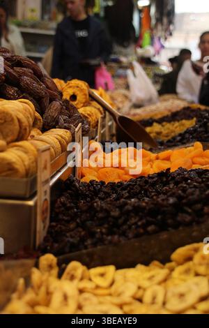 Eine bunte Auswahl an getrockneten Früchten und Datteln auf einem geschäftigen Markt im Nahen Osten, reich an Geschmack, Textur und Tradition. Stockfoto