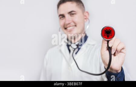 Doktor zeigt Stethoskop mit albanischer Flagge. Albaniens nationales Gesundheitskonzept Stockfoto