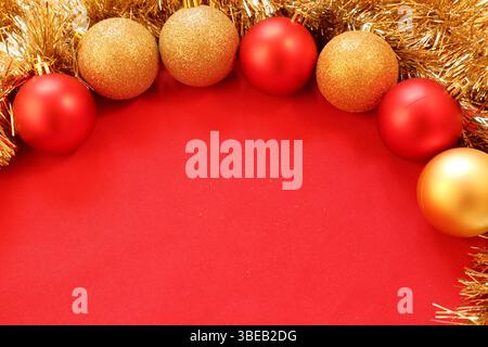 Weihnachtsdekoration. Eine runde Reihe glänzender Kugeln. Stillleben im minimalistischen Stil. Nahaufnahme und isoliert auf rotem Hintergrund. Innen. Kopierbereich. Stockfoto
