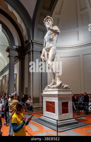 Menschenmassen schauen Michelangelos David, eine Skulptur aus Marmor, die in der Galleria dell’Accademia di Firenze, Florenz, Italien, ausgestellt ist Stockfoto
