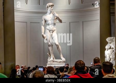 Menschenmassen schauen Michelangelos David, eine Skulptur aus Marmor, die in der Galleria dell’Accademia di Firenze, Florenz, Italien, ausgestellt ist Stockfoto