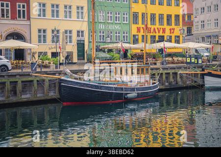 Ein Segelboot steht im Hafen von Nyhavn in der Nähe der Restaurants Heering und Nyhavn 17 in Kopenhagen, Dänemark, Europa Stockfoto