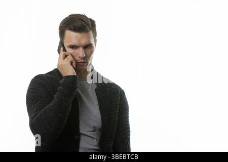 Porträt eines traurigen jungen Mannes, der am Telefon spricht Stockfoto