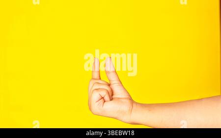 Eine menschliche Hand, die in einer gehaltenen Geste gefangen wird, isoliert vor einem hellen, einheitlichen Hintergrund. Dieses kontrastreiche Bild eignet sich perfekt für Werbemockups, UI/UX d Stockfoto
