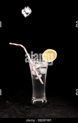 Ein Glas Limonade mit Strohhalm drin. Der Strohhalm befindet sich im Glas und der Zitronenkeil befindet sich oben auf dem Glas Stockfoto