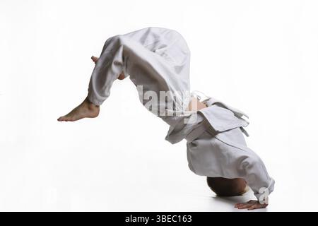Judo-Junge in weißem Kimono tuend sommersault Stockfoto