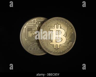 Zwei goldene Bitcoins auf schwarzem Hintergrund. Elektronisches Geld isoliert Stockfoto