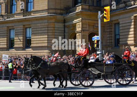 Ottawa, Kanada - 27. Mai 2025: Royal Canadian Mounted Police fährt Kutsche mit König Karl III. Und Königin Camilla während ihres Besuchs in Ottawa. Premierminister Mark Carney lud den König ein, die Thronrede anlässlich der Eröffnungssitzung des kanadischen parlaments zu halten. Eine riesige Menschenmenge wartete darauf, den König zu sehen. Stockfoto