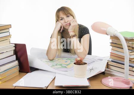 Das Mädchen ist traurig Schüler sitzen an einem Tisch, vollgestopft mit Büchern, Zeichnungen Stockfoto