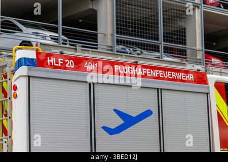Nürnberg, Deutschland - 25. Mai 2025: Nahaufnahme des Flughafenfeuerwehrfahrzeugs mit 'FLUGHAFENFEUERWEHR' in rot. Sie parkten vor dem Parkhaus mit anderen Fahrzeugen Stockfoto