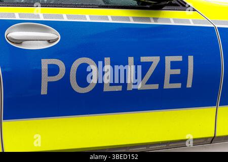 Nürnberg, Deutschland - 25. Mai 2025: Nahaufnahme der Seite eines Polizeiwagens mit 'POLIZEI' in reflektierendem Schriftzug, blauem Hintergrund und gelbem Streifen Stockfoto