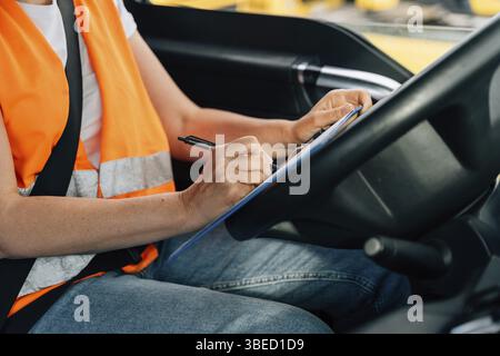 Reife Frau LKW-Fahrer Lenkrad in der LKW-Kabine. Glückliches Mittelalter-Lkw-Porträt. Stockfoto