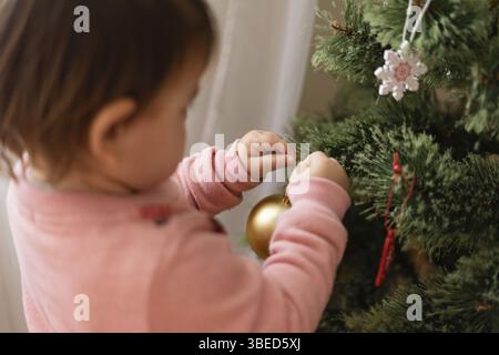 Kleinkind Mädchen Dekoration weihnachtsbaum zu Hause. Dezember Traditionen für Kinder. Stockfoto
