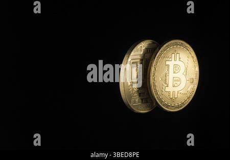 Zwei goldene Bitcoins auf schwarzem Hintergrund mit Kopierraum. Elektronisches Geld isoliert Stockfoto