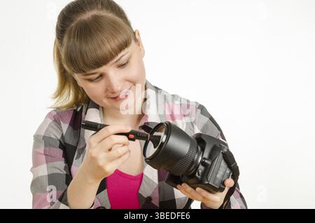 Fotograf-Bürste reinigt die Vorderseite des Objektivs auf die Kamera Stockfoto