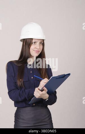 Junge Frau Baumeister in Helm stehend mit einem Ordner in der hand Stockfoto