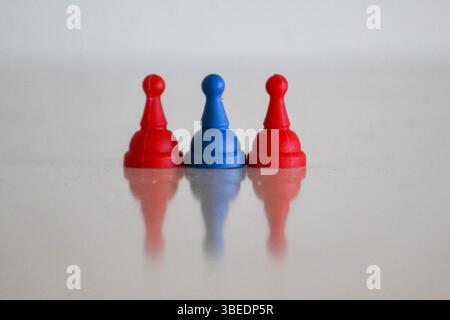 Drei Spielfiguren in den Farben der mongolischen Flagge – rot, blau und rot – symbolisieren Stärke, Freiheit und Tradition. Ein minimalistisch und behaglich Stockfoto