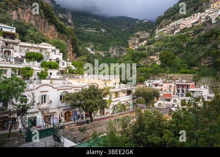 Terrassengebäude und üppige Hügel in Positano, Italien Stockfoto