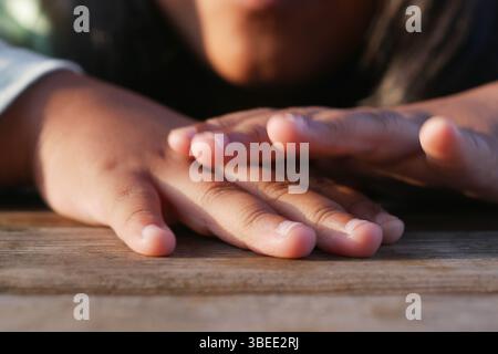 Während der goldenen Stunde liegen die Hände auf einer hölzernen Oberfläche Stockfoto