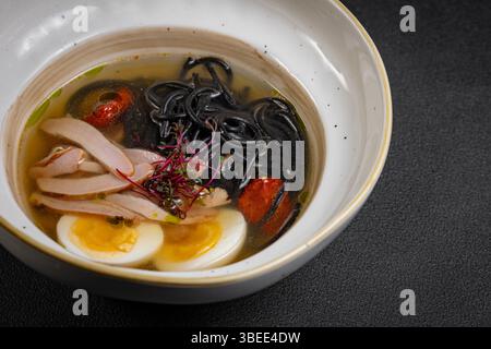 Hühnernudelsuppe. Currysuppe aus nächster Nähe japanisches Essen Chinesisches Gericht. Hühnersuppe mit truthahn und schwarzen Spaghetti. Stockfoto