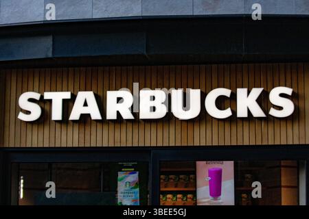 Nahaufnahme eines Starbucks-Schilds in London, das die Fassade bekannter Marken zeigt. Das Bild zeigt das Design des Storefront. Stockfoto